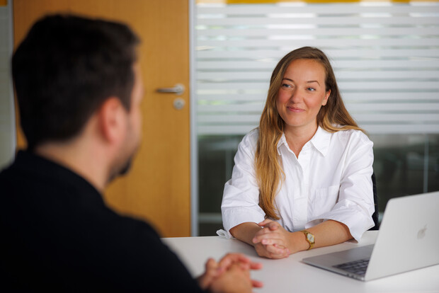 Two people in a meeting, looking reflecive