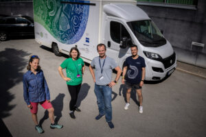 team of four people standing in front of the TREC bus