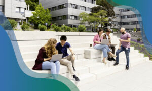 Five PhD students are seen sitting on a set of stairs outside EMBL's Imaging Centre.