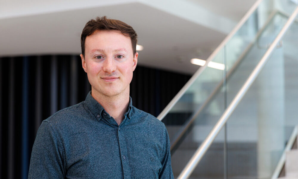 Male scientist standing in front of a set of stairs.