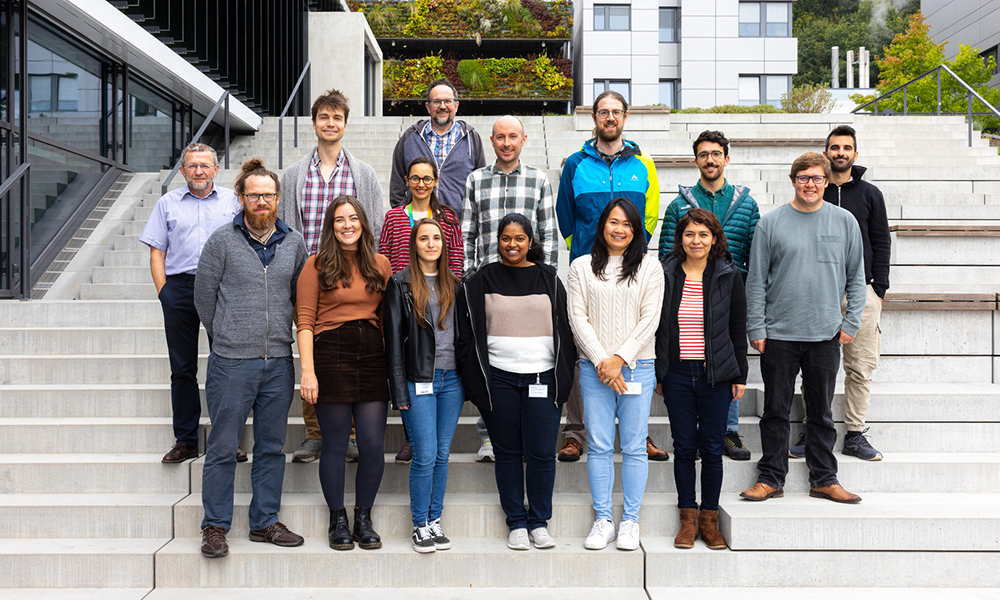 A mixed group of people standing on a set of stairs outside a building.