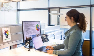 A woman at a desk looking at a computer screen displaying the new career resources website.