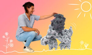 Photo of Sarah Gharbi (on the left) petting the head of a protein complex looking like a dog.